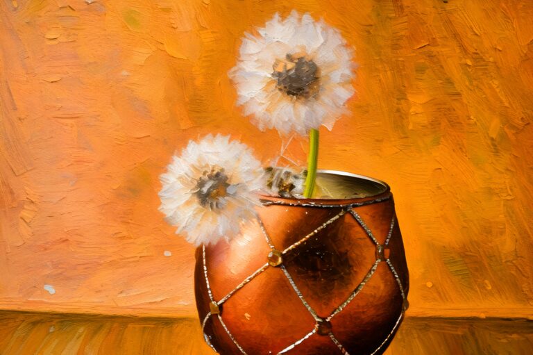 A decorative orange vase with a gold diamond pattern holds three fluffy white dandelion seed heads, set against a textured, warm orange background.