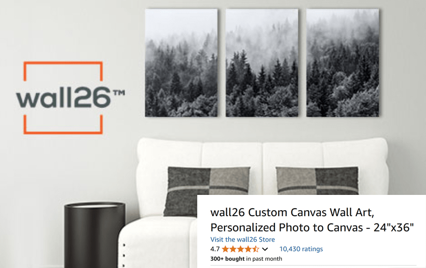 A living room features a white sofa and black side table, with a three-panel wall art of a misty forest above. The wall26 logo is on the left, and a product listing for custom canvas wall art is shown.